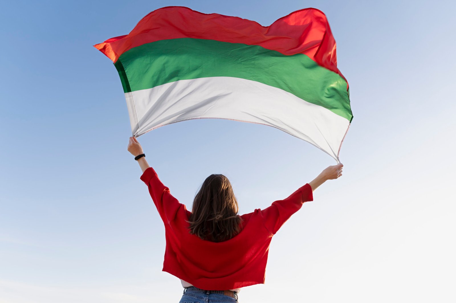 woman-holding-bulgarian-flag-against-blue-flag